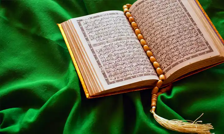 picture of an open holy quran on a green fabric